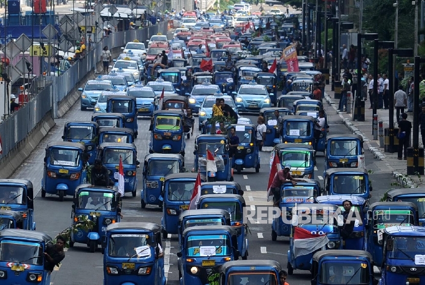 Demonstran tergabung dalam Paguyuban Pengemudi Angkutan Darat (PPAD) melakukan aksi unjuk rasa saat melintas di Bundaran HI, Jakarta, Selasa (22/3). (Republika/Tahta Aidilla)