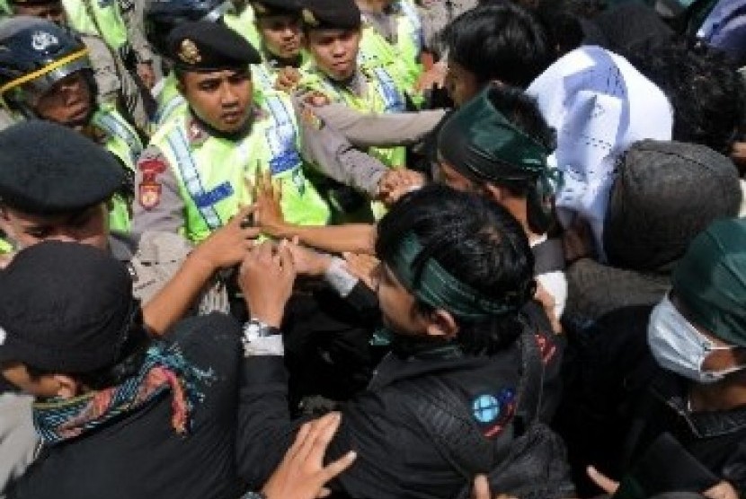 Ilustrasi polisi bentrok dengan pendemo. 