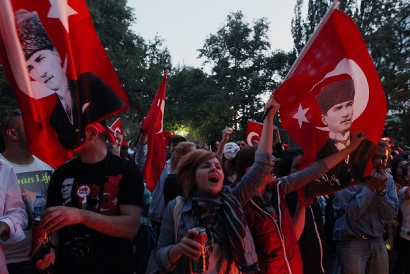 Demonstran Turki membawa bendera nasional serta potret pendiri Turki, Kemal Ataturk, dalam aksi demonstrasi anti-pemerintah di Ankara, Ahad, 9 Juni 2013. 