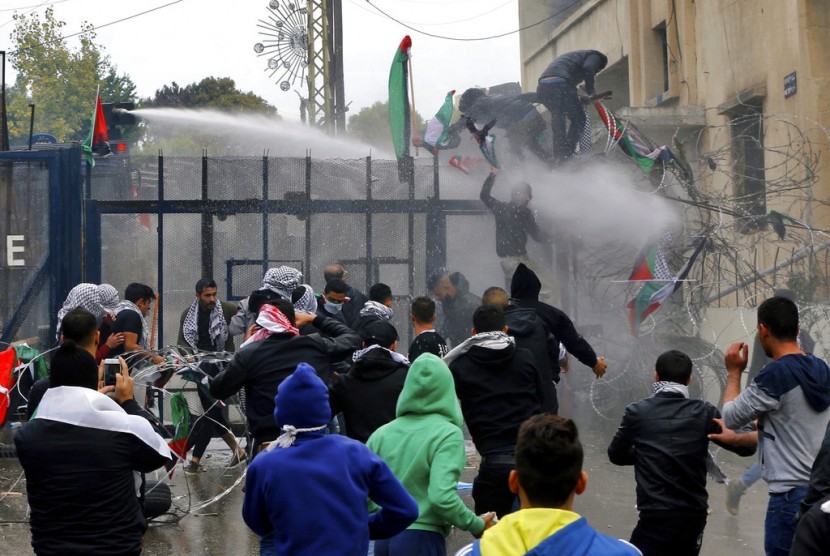 Demonstran yang mencoba memasuki Kedutaan Besar AS dihalau polisi antihuru-hara dengan water cannon di Aukar, timur Beirut, Lebanon, Ahad (10/12). Mereka memprotes AS yang mengakui Yerusalem sebagai ibu kota Israel.