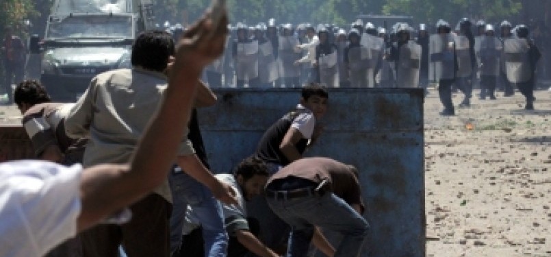 Demonstrans berhadapan dengan polisi Mesir di Lapangan Tahrir, Kairo