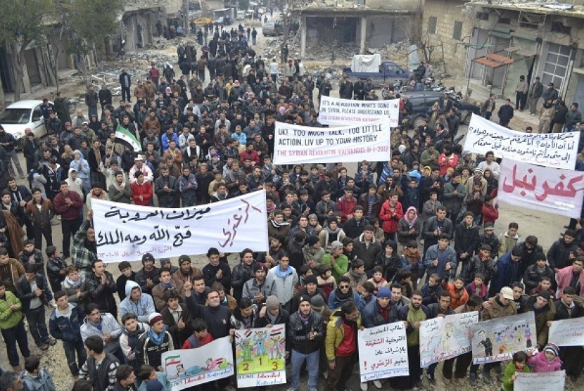 Demonstrators hold banners during a protest against Syria's President Bashar al-Assad, after Friday prayers in Kafranbel, near Idlib January 11, 2013.  