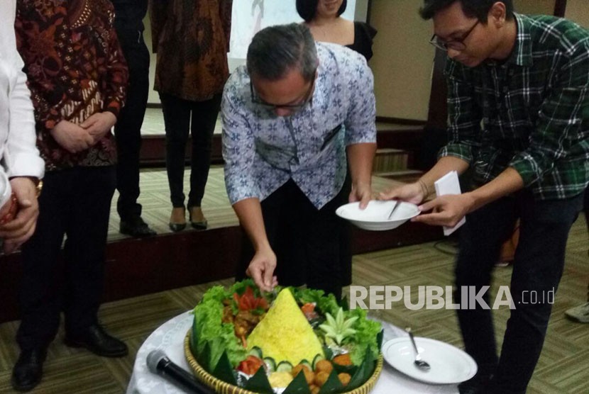 Deputi IV Bidang Pemasaran Bekraf Joshua Puji Mulia Simandjuntak memotong tumpeng sebagai tanda dimulainya pembuatan film Boundless Love, film China yang diproduksi di Indonesia, di Gedung Kementerian BUMN, Jakarta, Kamis (21/12).