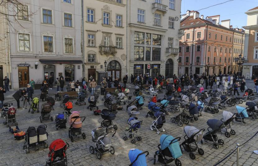 Deretan kereta bayi kosong dijejerkan di alun-alun pusat Kota Lviv di Ukraina barat sebagai simbol terenggutnya nyawa anak-anak dalam invasi Rusia, Jumat (18/3/2022).