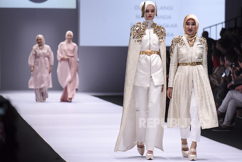 Desainer Dian Pelangi (kanan) berjalan bersama modelnya saat pembukaan acara Jakarta Fashion Week 2017 di Senayan City, Jakarta, Sabtu (22/10). Acara tahunan yang berlangsung hingga Jumat (28/10) tersebut akan menghadirkan karya dari 250 desainer dan label