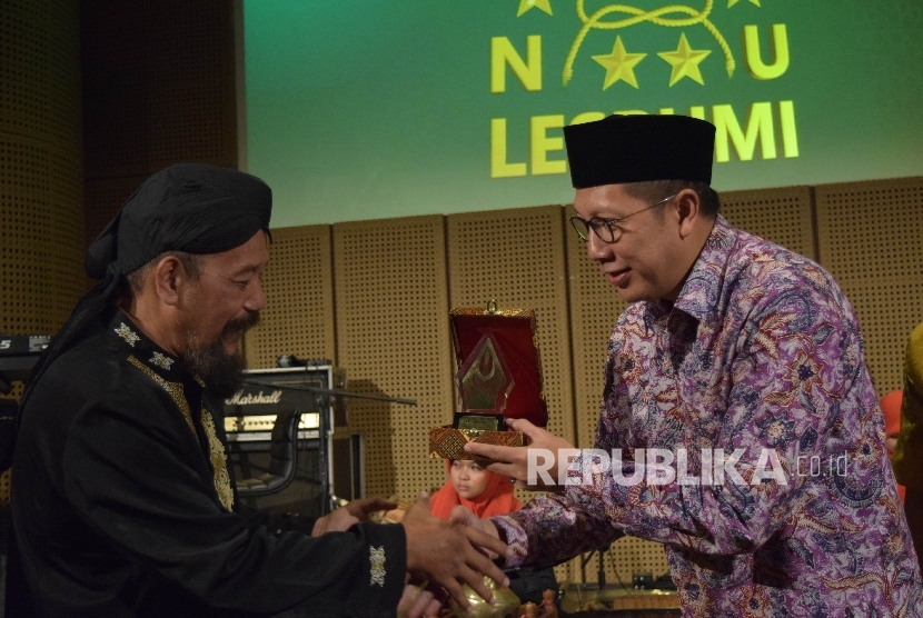 Menag Lukman Hakim Saifuddin menerima Anugerah Saptawirakrama dari Ketua LESBUMI PBNU Agus Sayoto (kiri) di Jakarta, Kamis (24/3).