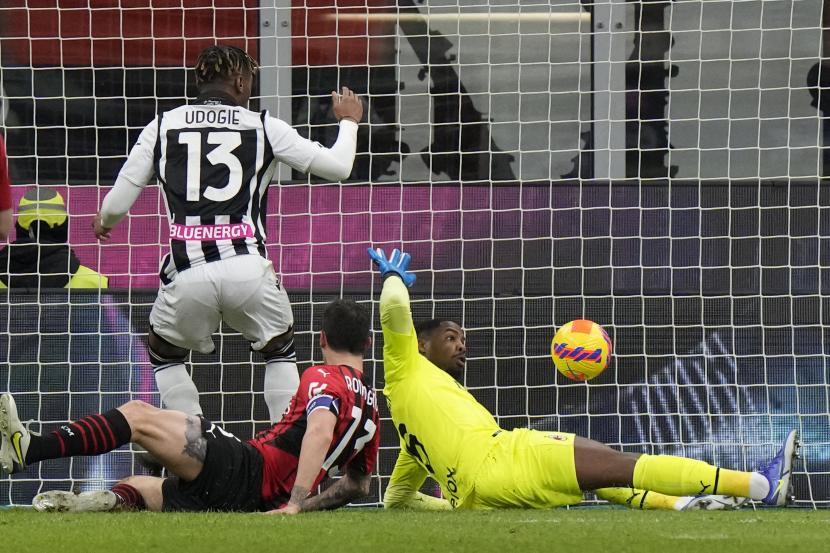 Destiny Udogie dari Udinese, kiri, mencetak gol pembuka timnya selama pertandingan sepak bola Serie A antara AC Milan dan Udinese, di stadion San Siro di Milan, Italia, Jumat, 25 Februari 2022. 