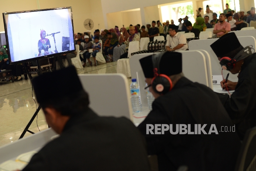 Dewan Hakim mendengarkan Kafilah Tuna Netra dari Gorontalo Sispagiarsih yang melantunkan ayat suci Al Quran saat babak penyisihan MTQ Nasional ke XXVI cabang Tilawah Al Quran yang diselenggarakan di Gedung Badan Kepegawaian Daerah Kota Mataram, Nusa Tengga