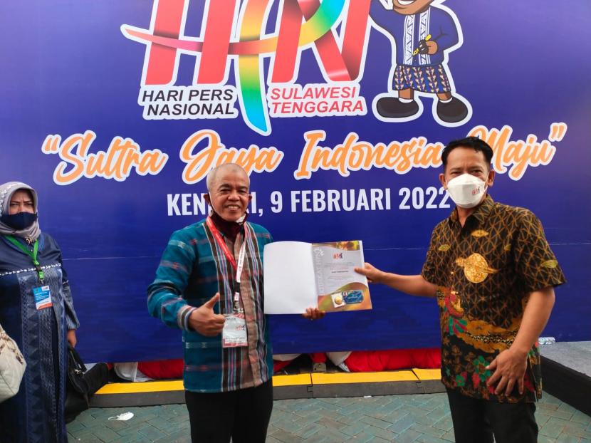 Dewan Kehormatan (DK) Persatuan Wartawan Indonesia (PWI) Pusat, Asro Kamal Rokan (kiri) memberikan sertifikat, pin emas dan kartu pers nomor satu atau Press Card Number One (PCNO) kepada wartawan Republika yang juga Ketua PWI Kota Depok, Rusdy Nurdiansyah di acara puncak Hari Pers Nasional (HPN) 2022 Kendari pada 9 Februari 2022.