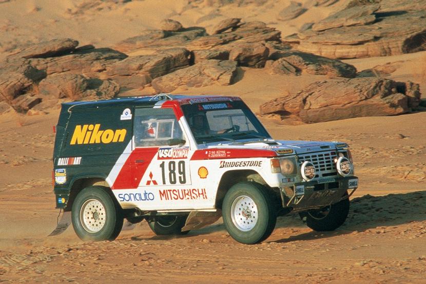 Di arena motor sport, Pajero berkompetisi untuk pertama kalinya di Rally Dakar, yang telah memiliki reputasi sebagai rally raid terberat di dunia pada 1983.