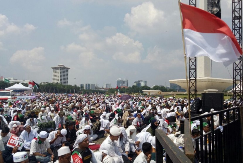 Di bawah terik matahari, ratusan ribu peserta Aksi Bela Palestina melaksanakan shalat Jumat berjamaah di area Monas, Jakarta Pusat, Jumat (11/5).