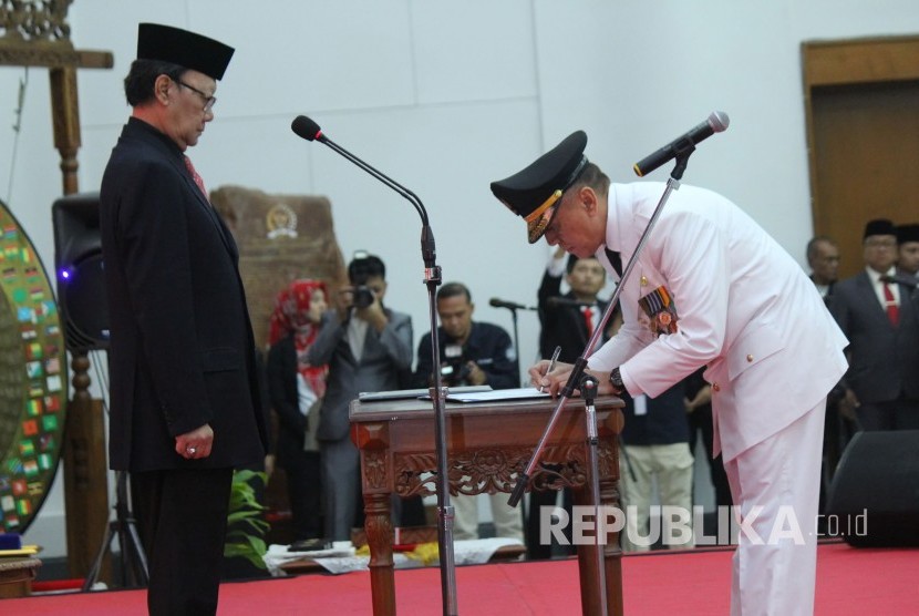 Di hadapan Mendagri Tjahjo Kumolo (kiri), Komjen Pol Mochamad Iriawan menandatangani jabatan Penjabat (Pj) Gubernur Jawa Barat, di Gedung Merdeka, Kota Bandung, Senin (18/6).