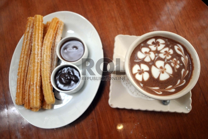 Di kafe-kafe Kota Madrid, Spanyol. hidangan churros bisa ditemukan dengan cocolan saus coklat juga segelas coklat panas.