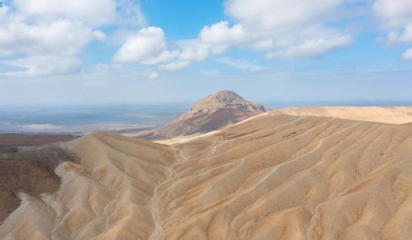 Di Madinah, Arab Saudi terdapat Jabal Al-Bidaa, sebuah gunung berapi yang terletak di tengah Harrat Khaybar. Hal itu karena warna putihnya yang menarik dan karena tersusun dari batuan comendit vulkanik. Sehingga menjadikan salah satu fitur geologis paling langka di Jazirah Arab. Gambaran  Kengerian Kiamat, Gunung-Gunung Hancur Beterbangan Layaknya Bulu