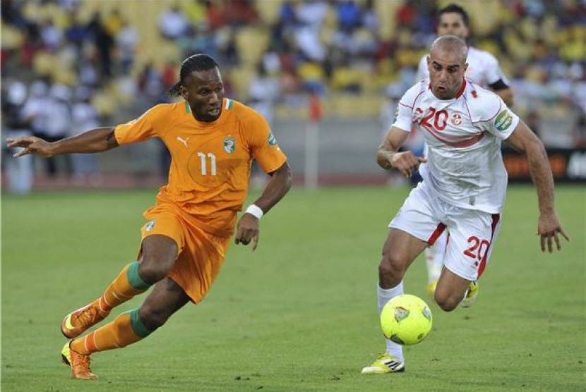 Didier Drogba (kiri), striker timnas Pantai Gading, berebut bola dengan pemain timnas Tunisia, Aymen Abdennour, di laga Grup D Piala Afrika 2013 di Rustenburg pada 26 Januari. 