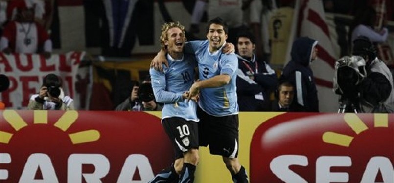 Diego Forlan dan Luis Suarez (kanan), dua striker andalan Uruguay, berpelukan usai Suarez mencetak gol ke jala Peru di babak semifinal Copa America 2011.