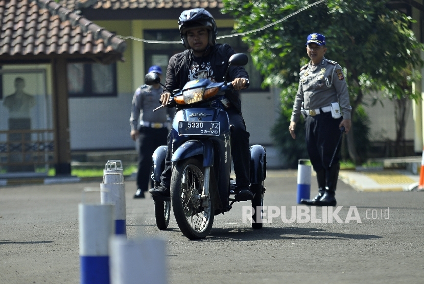 Difabel tuna daksa mengendarai sepeda motor saat acara sosialisasi dan pembuatan SIM D di Halaman Wyata Guna, Jalan Padjajaran, Kota Bandung, Kamis (25/5).