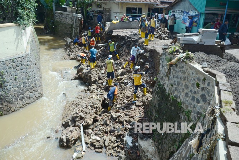 Dinas Pekerjaan Umum (DPU) Kota Bandung membereskan kirmir Sungai Cinambo yang ambrol, di Jalan AH Nasution, Kota Bandung, Senin (11/2).