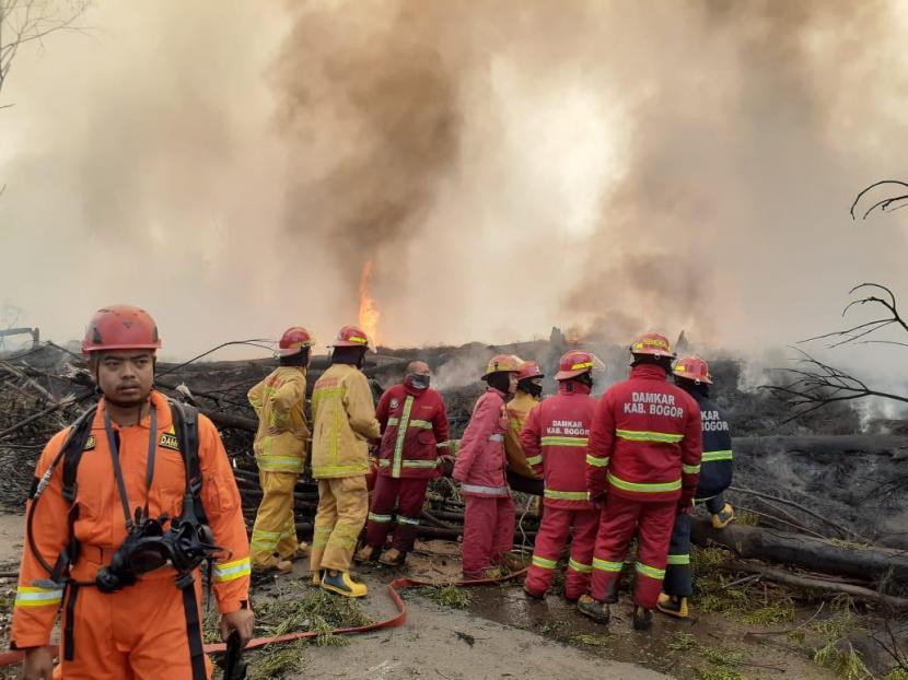 Dinas Pemadam Kebakaran Kabupaten Bogor berupaya memadamkan kebakaran dari tumpukan ban bekas di Cileungsi, Kabupaten Bogor