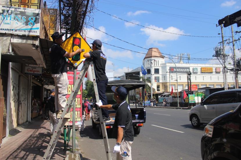 Dinas Perhubungan (Dishub) Kota Yogyakarta membersihkan rambu-rambu lalu lintas yang dicoret-coret, bahkan ditutup dengan stiker di sepanjang Jalan Urip Sumoharjo, Jumat (1/9/2023). 