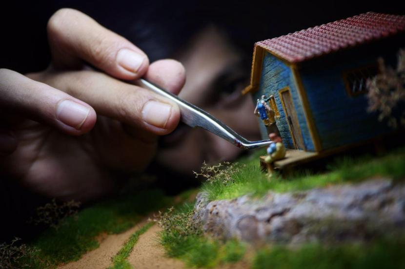 Diorama Maker Tristan tengah menata figur sebuah keluarga.