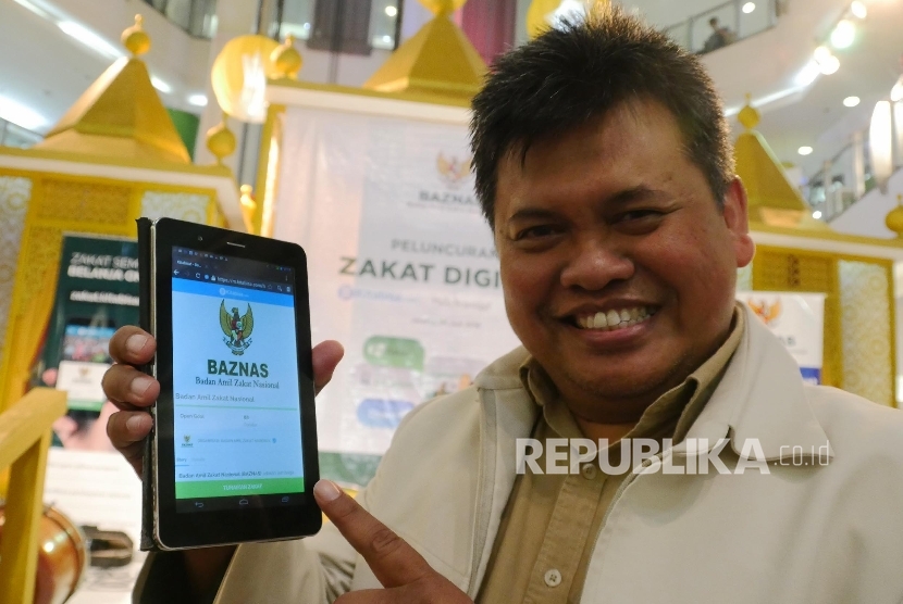Direktur Amil Zakat Nasional BAZNAS Arifin Purwakananta, memperlihatkan web Zakat Digital pada peluncurannya di Jakarta, Jumat (24/6). (Republika/Darmawan)