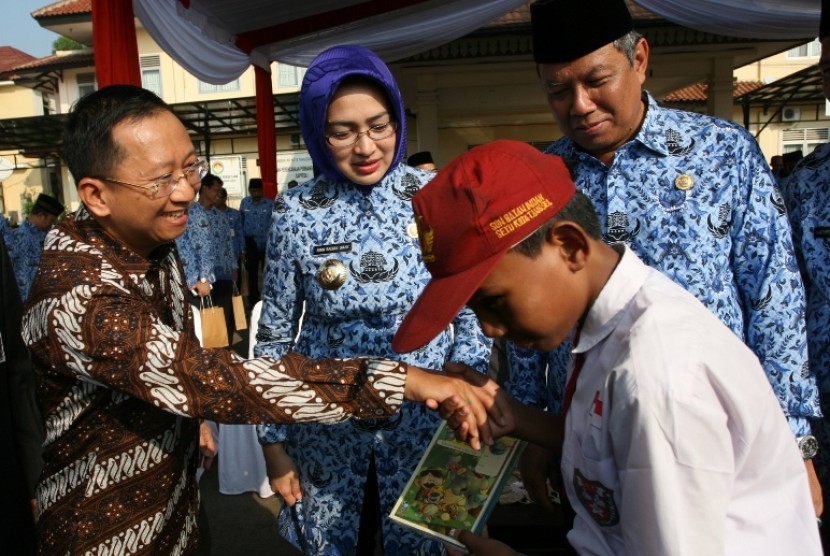 Direktur APP Suhendra Wiriadinata bersama Wali Kota Tangsel Airin Rachmi memberikan bantuan buku tulis kepada siswa SD di Lapangan Cilenggang, Tangsel (18/5).