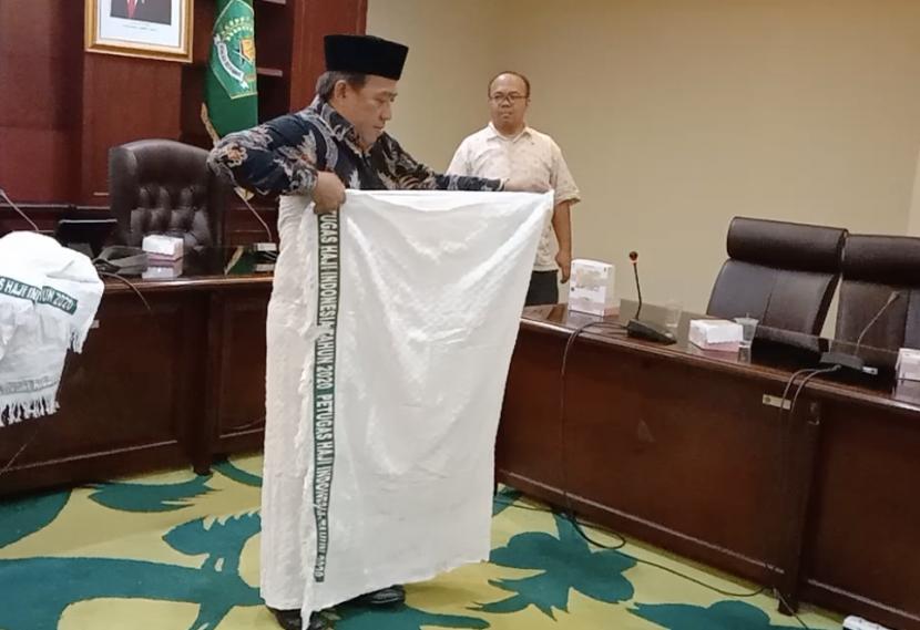 Direktur Bina Haji Arsad Hidayat melakukan simulasi pemakaian kain ihram saat mengisi materi Manasik Haji dalam acara Edukasi Media Center Haji (MCH) di gedung Kementerian Agama, Jakarta, Rabu (25/5). 