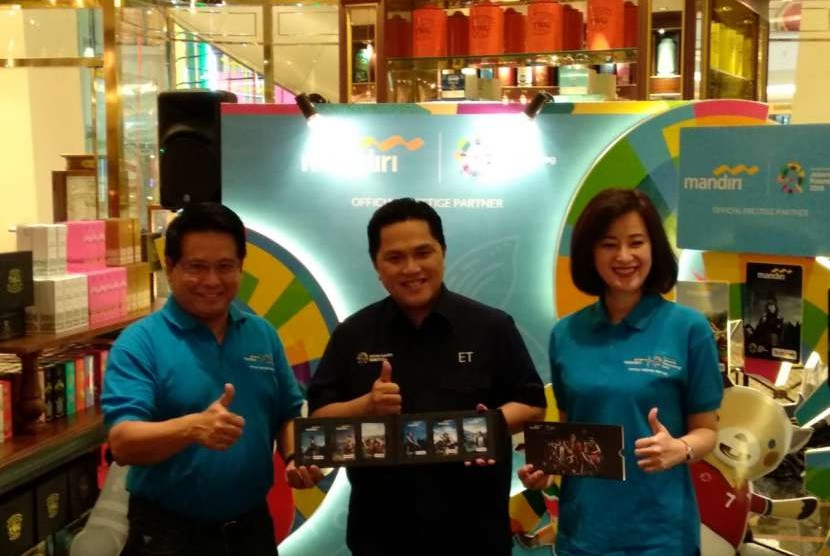 Direktur Bisnis Kecil dan Jaringan Bank Mandiri Hery Gunardi (kiri) dan Ketua Inasgoc Erick Thohir (tengah) berfoto menujukan kartu uang elektronik Bank Mandiri E-Money edisi khusus Energy of Asia untuk Asian Games 2018 di Mall Pacific Place, Rabu (15/8). 