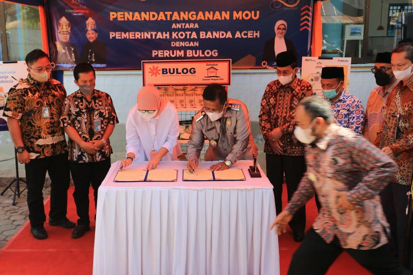Direktur Bisnis Perum Bulog Febby Novita (tiga kiri) dan Wali Kota Banda Aceh Aminullah Usman (keempat kiri) melakukan penandatanganan MOU penyediaan komoditi pangan antara Pemerintah Kota Banda Aceh dan Perum Bulog pada penyerahan bantuan beras Fortivit untuk pencegahan stunting di Desa Lam Ara, Banda Aceh, Aceh, Kamis (21/4/2022). Perum Bulog menyalurkan bantuan pangan beras bervitamin (beras fortivit) sebanyak 3.330 kilogram sebagai upaya pencegahan dan percepatan penurunan angka stunting di Indonesia.