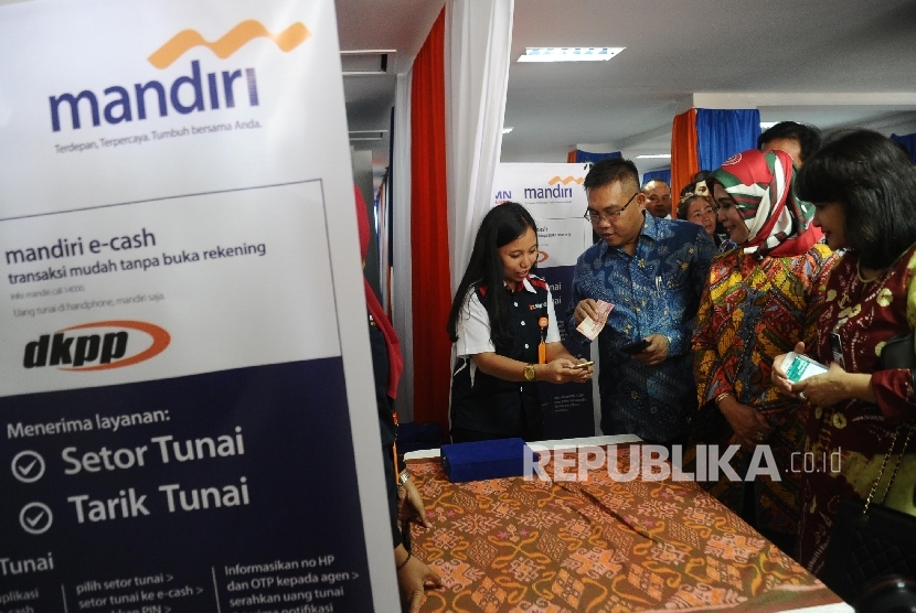 Direktur Commercial Banking Bank Mandiri Kartini Sally, Direktur Utama PT Dian Kencana Puri Prima (DKPP) Dian Hariani dan Direktur Digital Banking & Technology Bank Mandiri Rico Usthavia Frans (dari kanan) melakukan transaksi kepada agen usai peluncuran ke