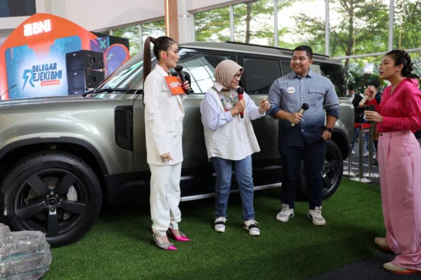 Direktur Consumer Banking BNI Corina Leyla Karnalies (tengah kiri), Ayu Dewi (kiri), Sigi Wimala (kanan), dan Milenial BNI (tengah kanan) berbincang di depan grand prize Land Rover Defender 110 dalam Program Gelegar Rejeki BNI #GaPakeNanti, Minggu (16/10/2022).