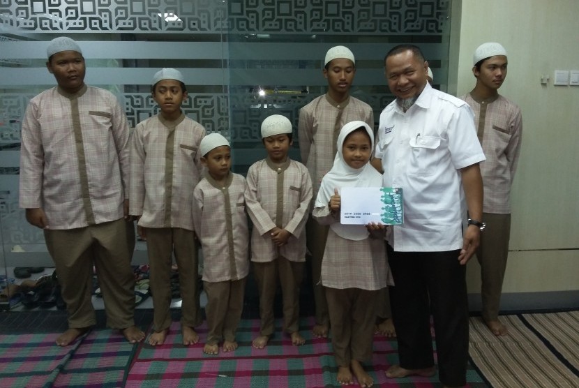 Direktur Eksekutif Baitulmaal Muamalat (BMM) Bambang Kusnadi menyerahkan santunan kepada anak-anak yatim dan dhuafa di kantor Bank Muamalat Cabang Kelapa Gading Jakarta,  Rabu (23/12).