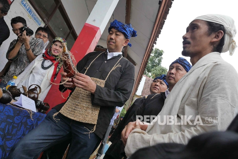 Direktur Enterprise dan Business Service PT Telkom Indonesia Muhammad Awaluddin (kedua dari kanan) membeli madu produksi UKM kampung Baduy disaksikan sesepuh Baduy Dalam Ayah Mursid (kanan) di Kampung Ciboleger Kenekes, Kab Lebak, Banten, Jumat (19/8).