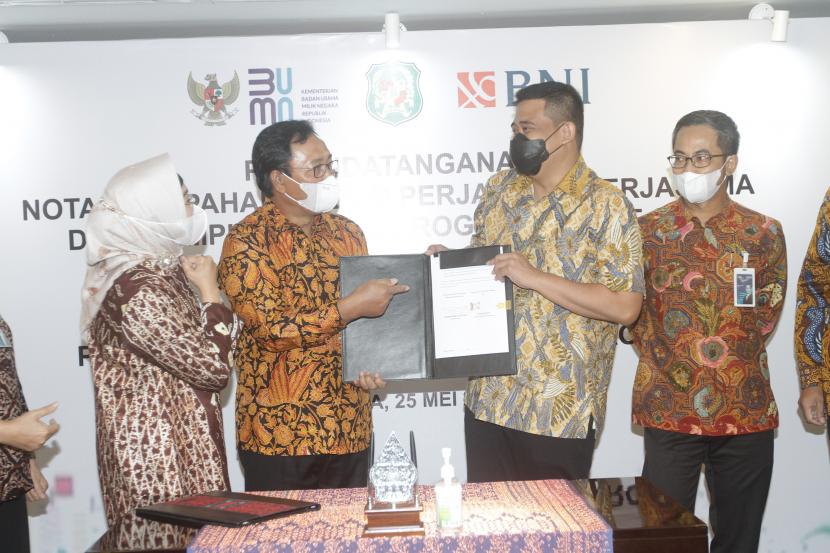 Direktur Hubungan Kelembagaan BNI Sis Apik Wijayanto (kedua kiri) dan Walikota Medan Muhammad Bobby Afif Nasution (kedua kanan) menandatangani Nota Kesepahaman (MoU) tentang Penggunaan Fasilitas Layanan Jasa Perbankan dan Dukungan Program Smart City di Jakarta, Selasa (25 Mei 2021). Penandatangan tersebut disaksikan oleh Wakil Direktur Utama BNI Adi Sulistyowati ( kiri) dan Direktur Layanan dan Jaringan BNI Ronny Venir (kanan). 