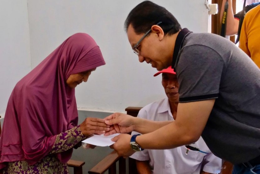  Direktur Human Capital Management Telkom Edi Witjara (kanan) menyerahkan kunci rumah dalam program Bedah Rumah Telkom 2019 kepada Ibu Ratna di Desa Babakan Peuteuy, Kecamatan Cicalengka, Kabupaten Bandung, Jumat  (4/10). 