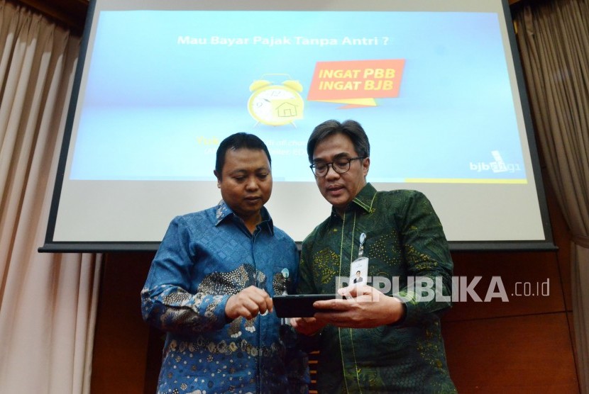 Direktur IT, Treasury dan International Banking Bank BJB Rio Lanasier (kiri) dan Direktur Operasional Bank BJB Tedi Setiawan berbicang saat konferensi pers tentang berbagai inovasi dan kemudahan yang diberikan untuk nasabah setia, di Auditorium BJB University, Kota Bandung, Selasa (13/8).