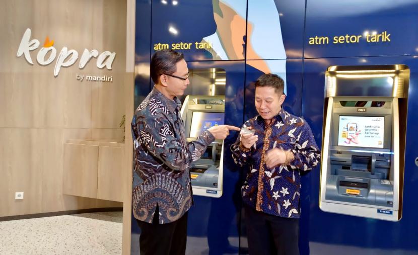Direktur Jaringan dan Retail Banking Bank Mandiri Aquarius Rudianto (kanan) saat mencoba bertransaksi di ATM Bank Mandiri.