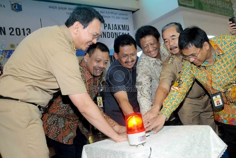 Direktur Jenderal Pajak, Kementerian Keuangan, Sigit Priadi Pramudito (kedua kiri) serta Gubernur DKI Jakarta Basuki Tjahaja Purnama (kiri) meresmikan pembukaan Gerai Layanan Terpadu di Pasar Tanah Abang, Jakarta Pusat, Selasa (1/9).