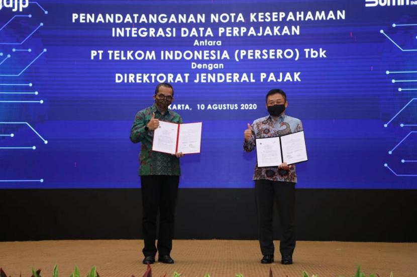 Direktur Jenderal Pajak Suryo Utomo (kiri) dan Direktur Utama Telkom Ririek Adriansyah (kanan) berbincang usai penandatanganan Nota Kesepahaman Integrasi Data Perpajakan antara Telkom Indonesia dan Direktorat Jenderal Pajak di Jakarta, Senin (10/8).