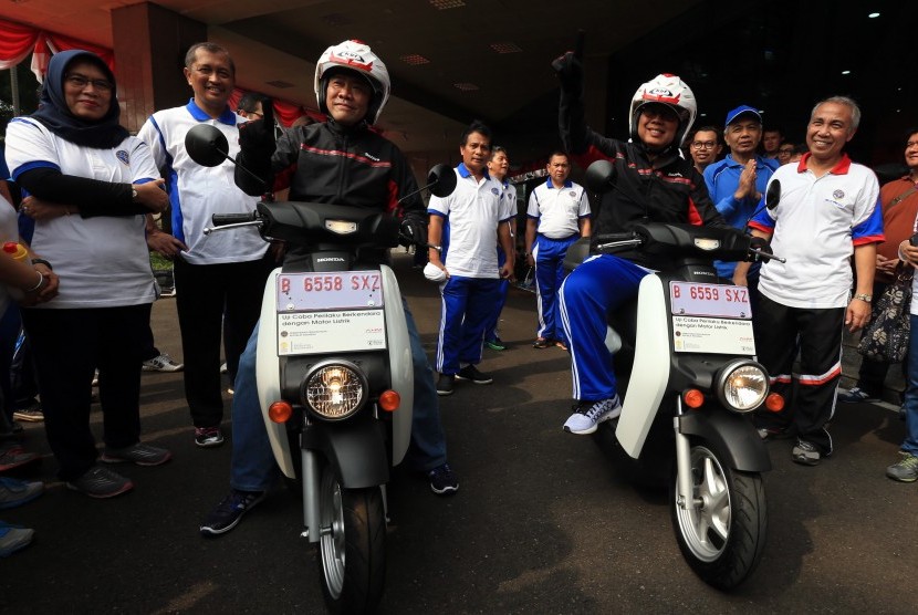 Direktur Jenderal Perhubungan Darat Kementerian Perhubungan Pudji Hartanto (kanan) bersama dengan Direktur Marketing AHM Margono Tanuwijaya (kiri), mencoba motor listrik Honda EV Neo saat uji coba perilaku berkendara sepeda motor listrik di Jakarta