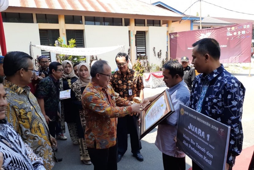 Direktur Jenderal Perkebunan Kasdi Subagyono memberikan sertifikat dan piala kepada kelompok tani dari Lombok Utara yang menjadi pemenang lomba kebun kakao berproduksi tinggi di acara puncak peringatan Hari Kakao Nasional 2019 di Kabupaten Solok, Sumatra Barat, Sabtu (5/10).