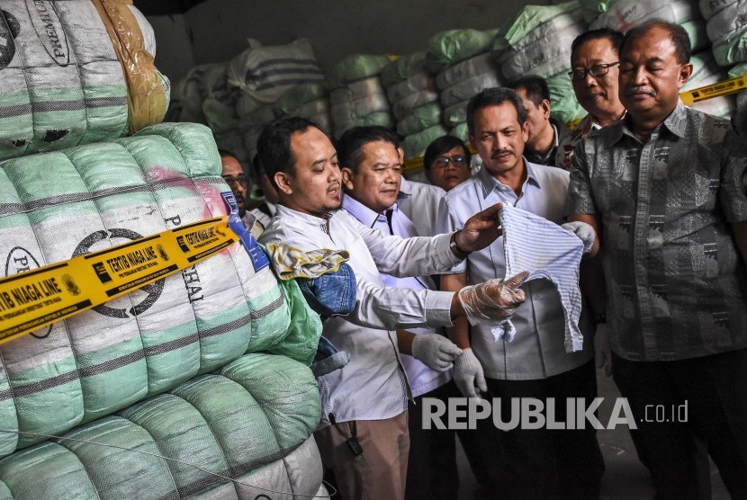 Direktur Jenderal Perlindungan Konsumen dan Tertib Niaga (PKTN) Kementerian Perdagangan, Veri Anggrijono (tengah) memeriksa barang bukti berupa pakaian bekas impor ilegal yang disita di gudang kawasan Gedebage, Kota Bandung, Kamis (5/9).