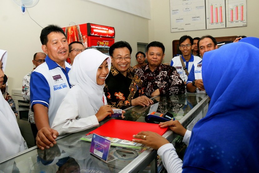 Direktur Kelembagaan BRI Kuswiyoto (paling kiri) dan Dirjen Pendidikan Dasar dan Menegah Hamid Muhammad (ketiga kiri) menyaksikan uji coba Kartu Indonesia Pintar Plus di Yogyakarta, Rabu (19/10).