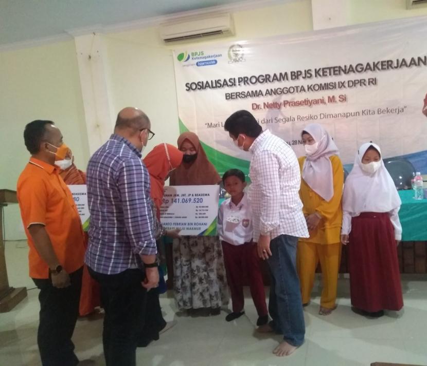 Direktur Kepesertaan BPJS Ketenagakerjaan, Zainudin (baju putih) menyaksikan penyerahan klaim program BPJS Ketenagakerjaan kepada ahli waris peserta, di Islamic Center Kabupaten Indramayu, Ahad (28/11). 