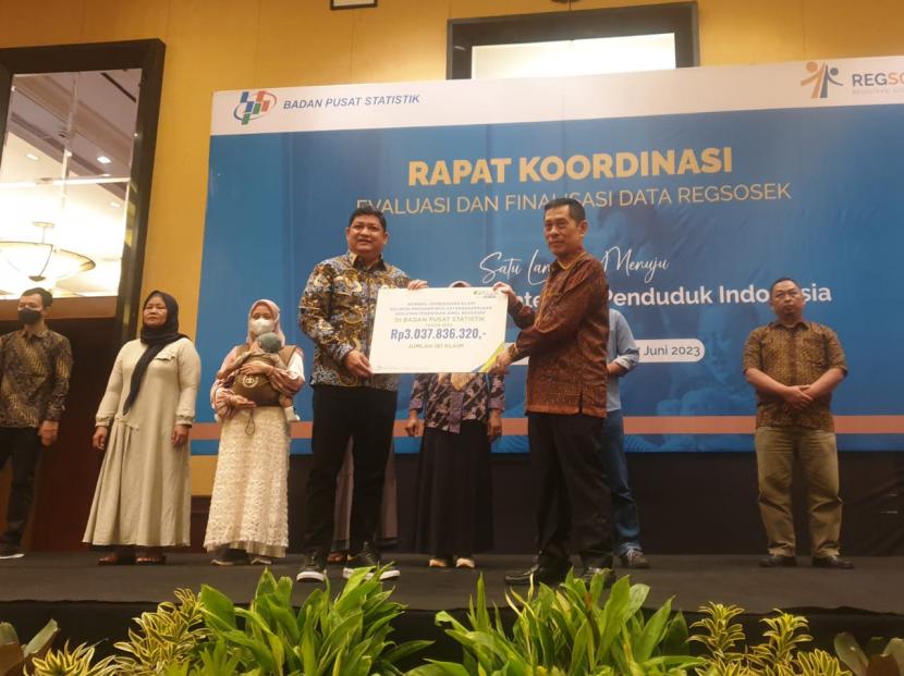 Direktur Kepesertaan BPJS Ketenagakerjaan Zainudin menyerahkan santunan secara simbolis kepada Sekretaris Utama Badan Pusat Statistik (BPS) RI Atqo Mardiyanto. Kamis (15/6).