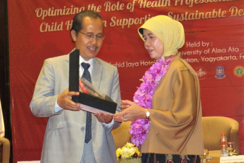 Direktur Kesehatan Keluarga Kementerian Kesehatan, Eni Gustina, menerima cenderamata dari Rektor UAA, Hamam Hadi.