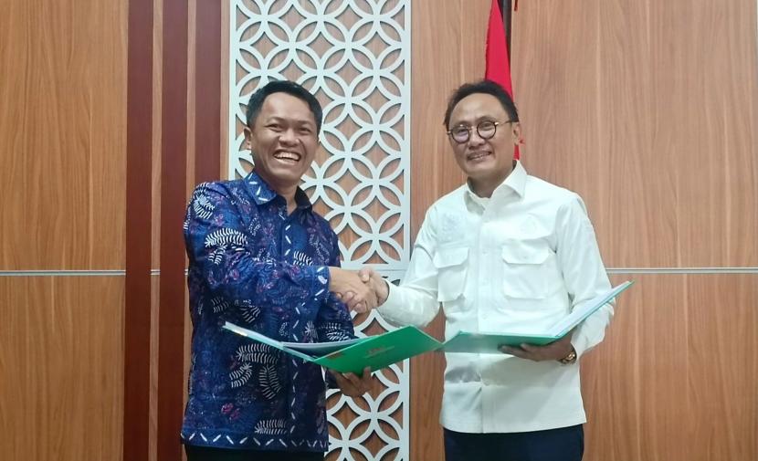 Direktur Keuangan dan Strategi PT Bank Muamalat Indonesia Tbk Suhendar (kiri) dan Kepala Badan Penyelenggara Jaminan Produk Halal (BPJPH) Muhammad Aqil Irham (kanan) bersalaman saat penandatanganan perjanjian kerja sama pembayaran sertifikasi halal di Jakarta, Senin (19/6/2023).
