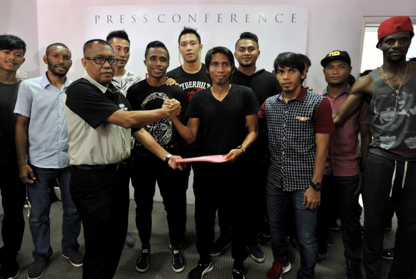 Direktur Klub PSM Makassar Sumirlan (kiri) berjabat tangan dengan kapten PSM Makassar Syamsul Haeruddin (kanan) disaksikan sejumlah pesepakbola PSM Makassar usai menandatangani kontrak di Sekretariat PSM Makassar, Sulawesi Selatan, Kamis (3/3).