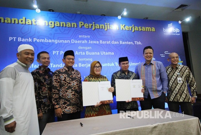 Direktur Konsumer Bank Bjb Suartini dan Dirut PT Praba Arta Buana Utama Afipuddien, memperlihatkan Perjanjian Kerjasama tentang Pemanfaatan Tandamata Berjangka Untuk Tujuan Umroh, di gedung Bank BJB, Jalan Naripan, Kota Bandung, Senin (15/4). 